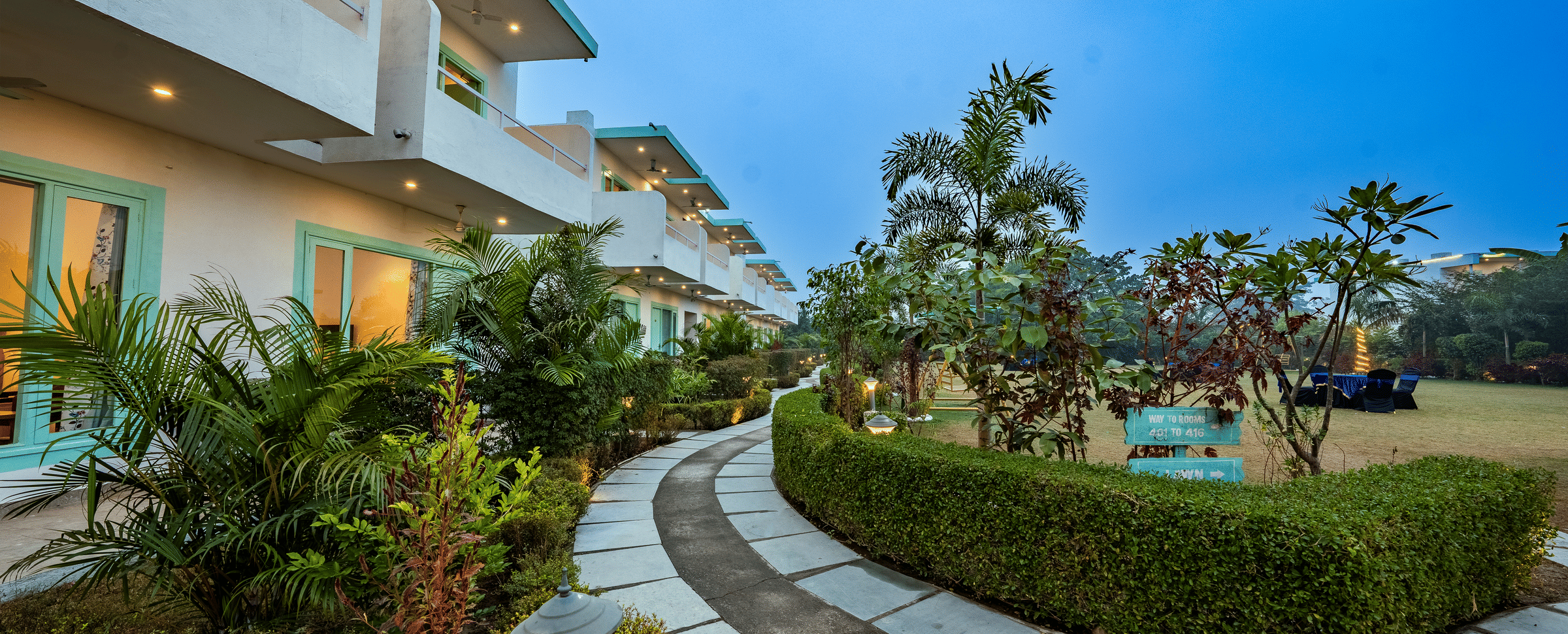 Exterior view of rooms at Vedikant Resorts The Mallard Corbett, framed by trees on either side