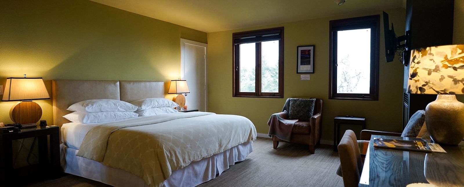Warm and inviting hotel room with soft lighting, a plush bed, and a scenic view from the window - Brewery Gulch Inn & Spa