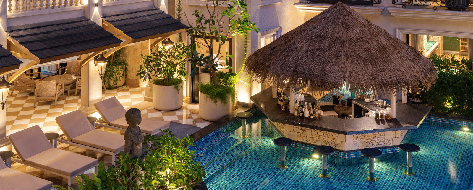 Close-up shot of the Splash Pool Bar featuring a pool-side bar counter cover with thatched roof at The Evren, Vagator.