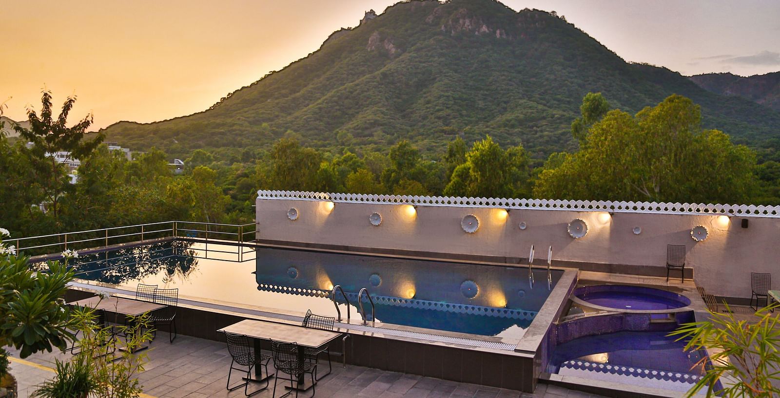A pool with a view of mountains. - Bamboo Saa Resort & Spa, Udaipur