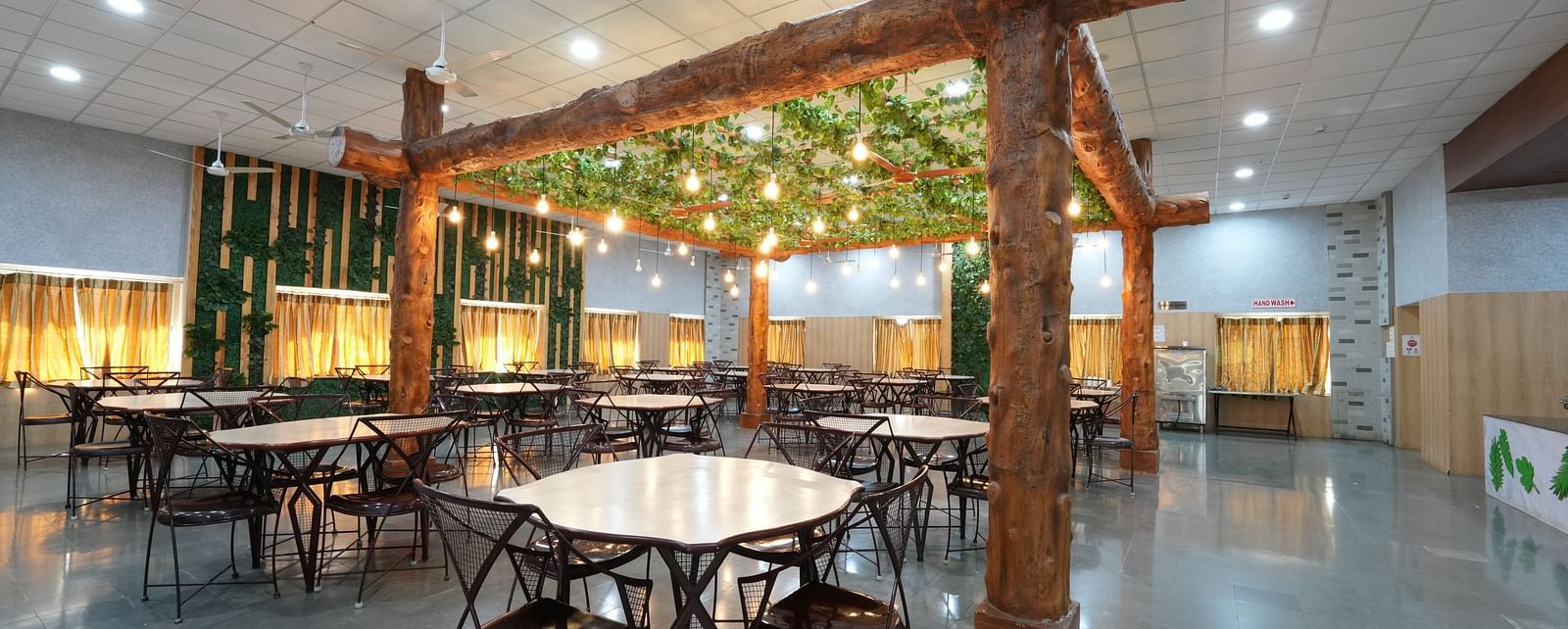 Dining tables and chairs placed in Greens Inn Restaurant - Fine Dining in Hyderabad.