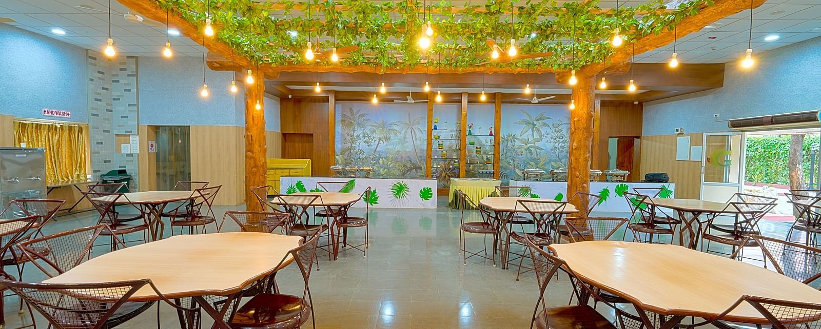 Dining tables and chairs placed in Greens Inn Restaurant - Top Restaurant in Hyderabad.