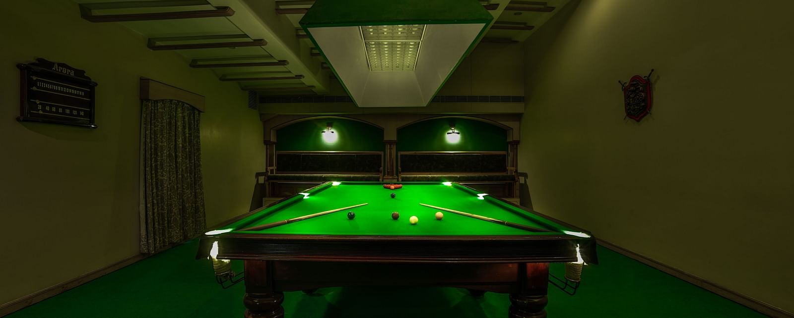 Pool table with billiards cue sticks placed at the corners at Tara, Comfort Hotel in Hyderabad - Ramoji Film City.