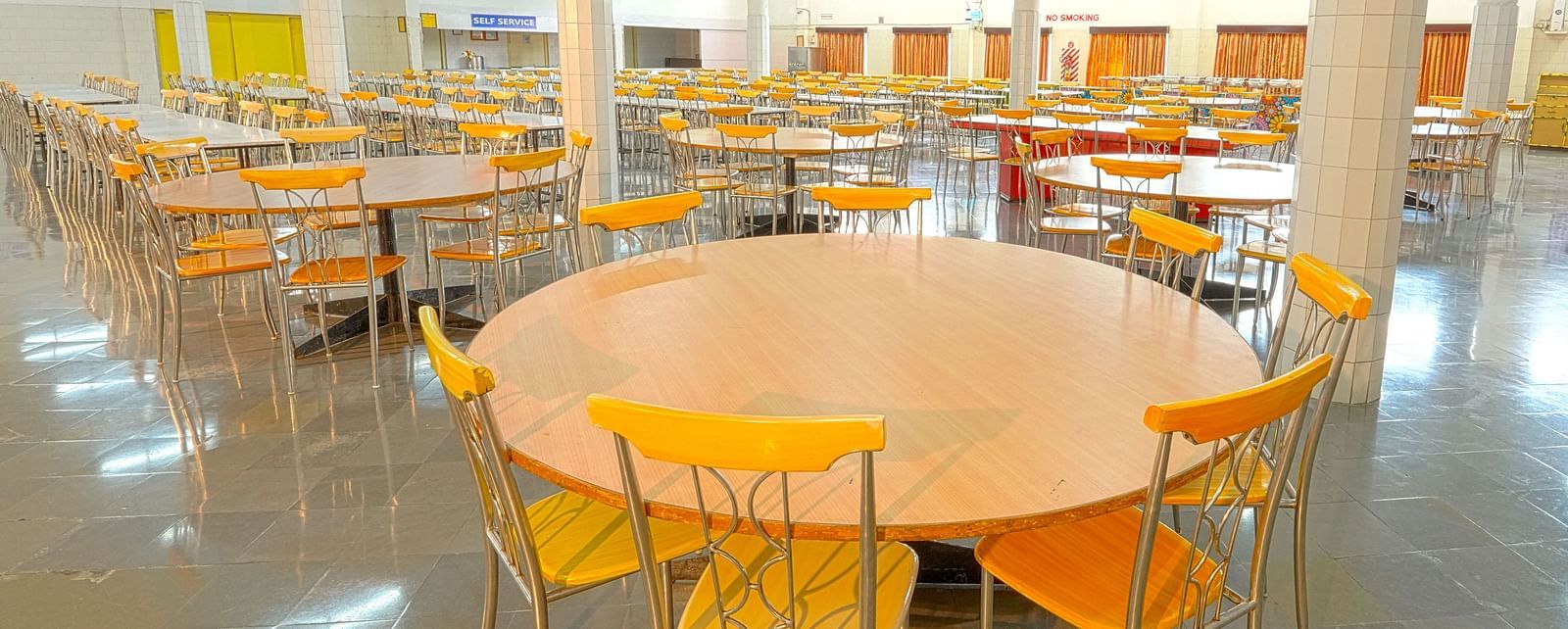 A colourful cafeteria with round tables at Sahara - Cozy Dining in Hyderabad.