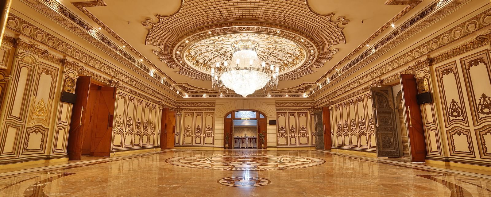 Interiors of Rang Mahal hall A grand hotel suite with an opulent red and white decor, large bed, and seating area, reflecting a traditional style at Sitara Luxury Hotel in Hyderabad near Ramoji Film City.