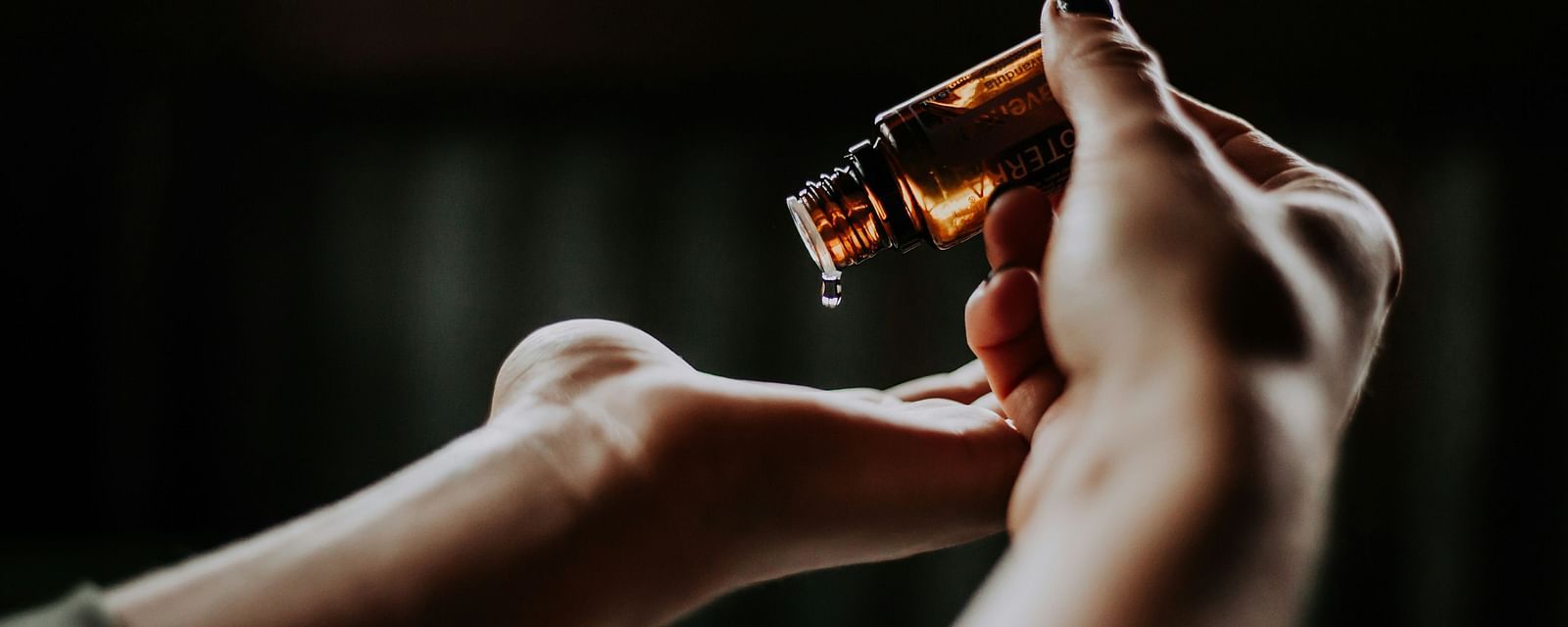A person pouring essential oils on their hand