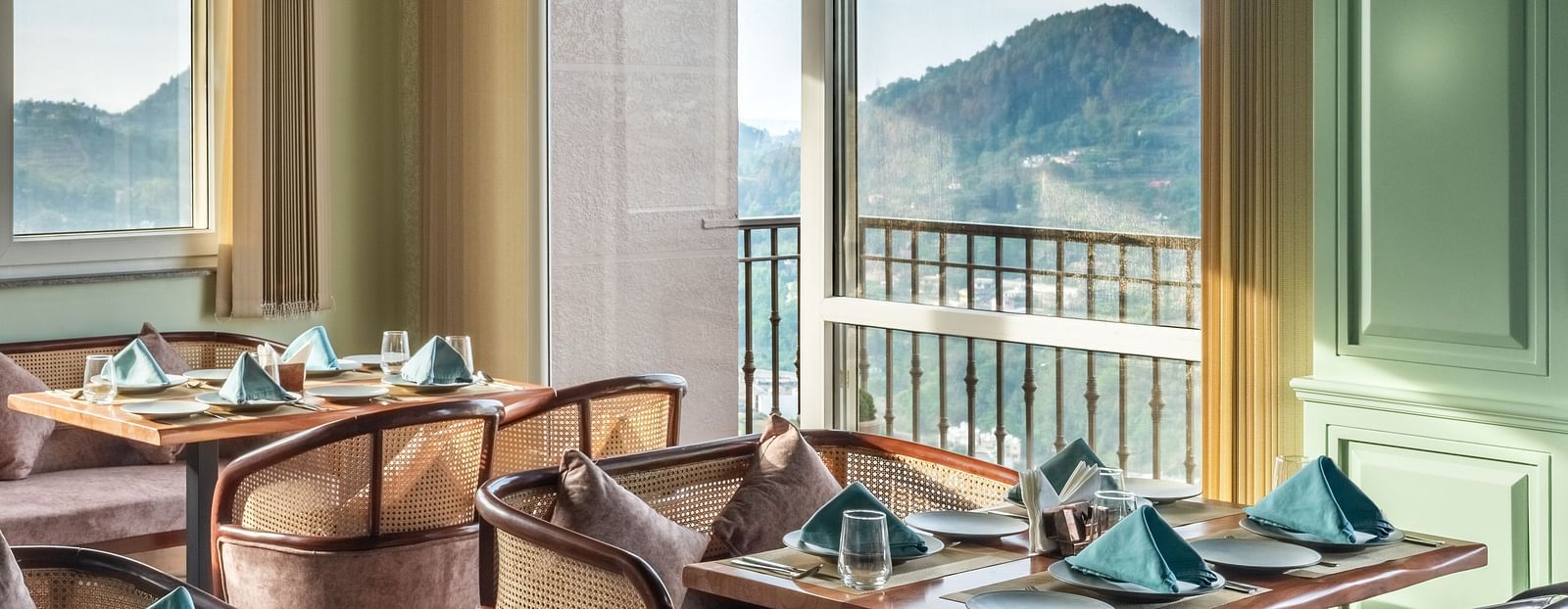 an image of a dining space filled with natural light, chairs and tables are placed with cutlery and hand towels at Mountoria Retreat, Naukuchiatal