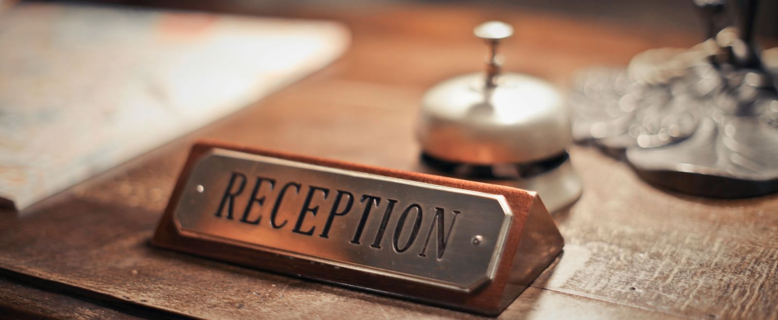 Close-up of a reception desk with a nameplate, bell, and service items
