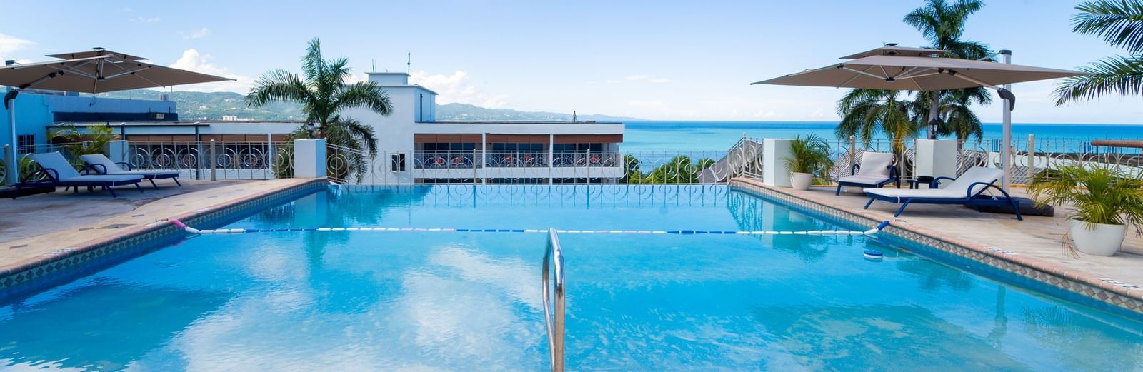 A close up shot of a pool with clear water and views of Montego Bay in the background - Hotel 39, Jamaica (Montego Bay)