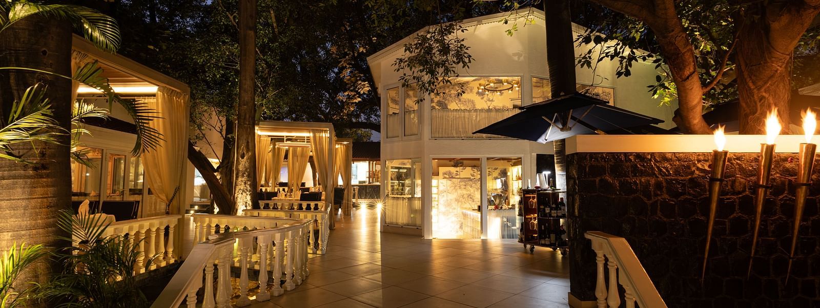 Sevilla restaurant entrance at The Claridges New Delhi, beautifully illuminated at night, showcasing its charming alfresco and indoor dining spaces