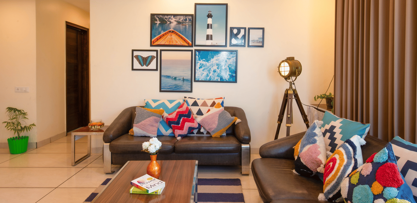 A living room at Perfectstayz Value Shimla (Namah Retreat) with 2 sofas, a coffee table, wall art, a floor lamp, curtains, and an indoor plant.