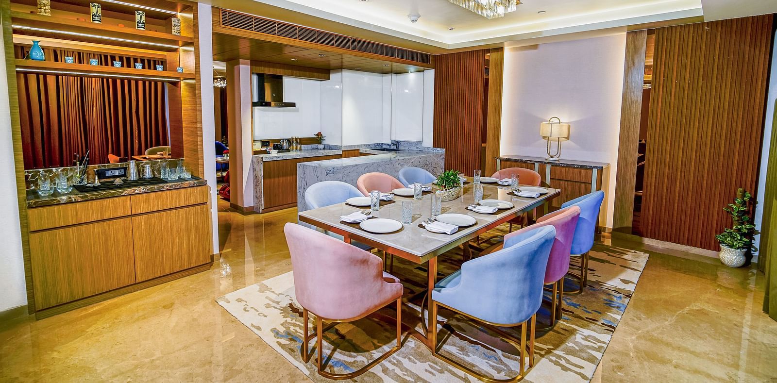 An image of the dining room in Grand Velammal Suite with upholstered chairs placed around a square-shaped glass table