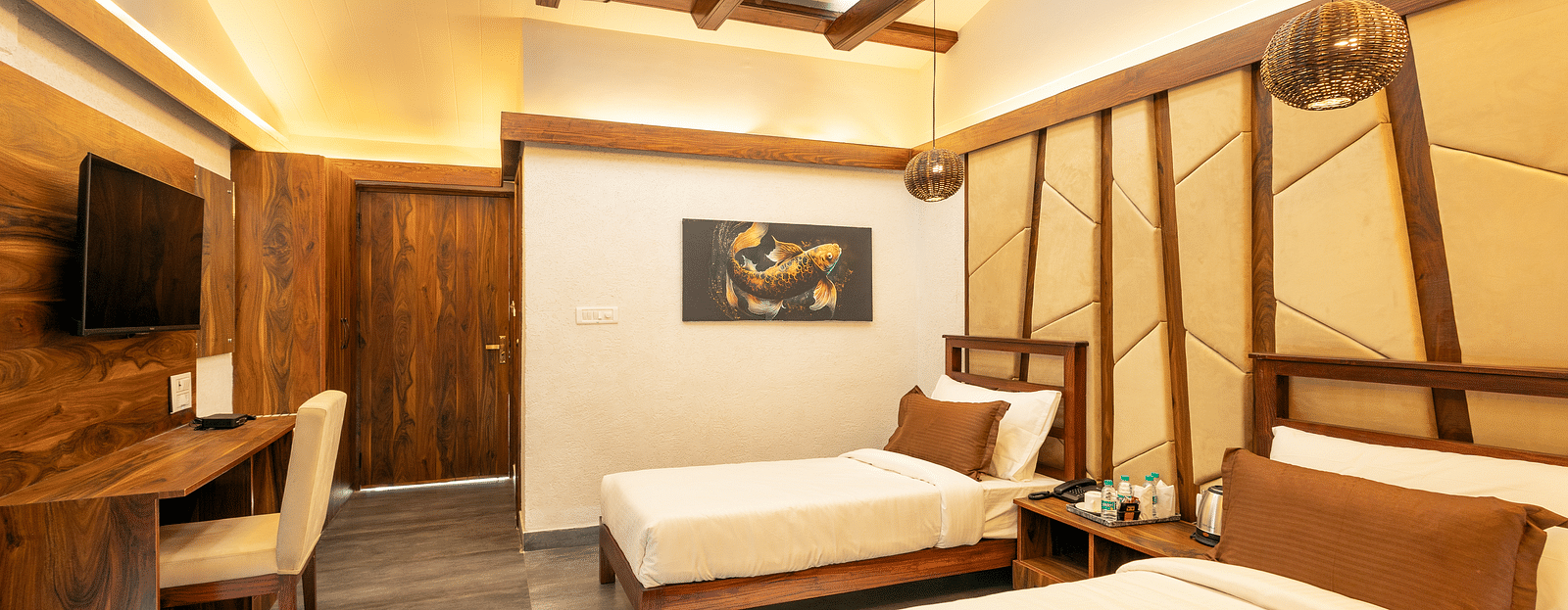 Twin beds facing the TV of River View Room at the Sylvan Retreat, Dehradun. 