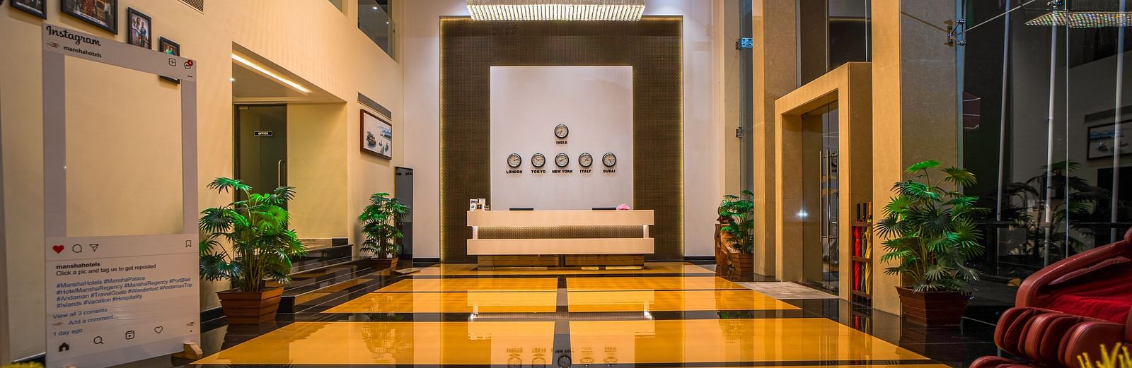 A brightly lit hotel hallway with polished floors and plants | Mansha Hotels