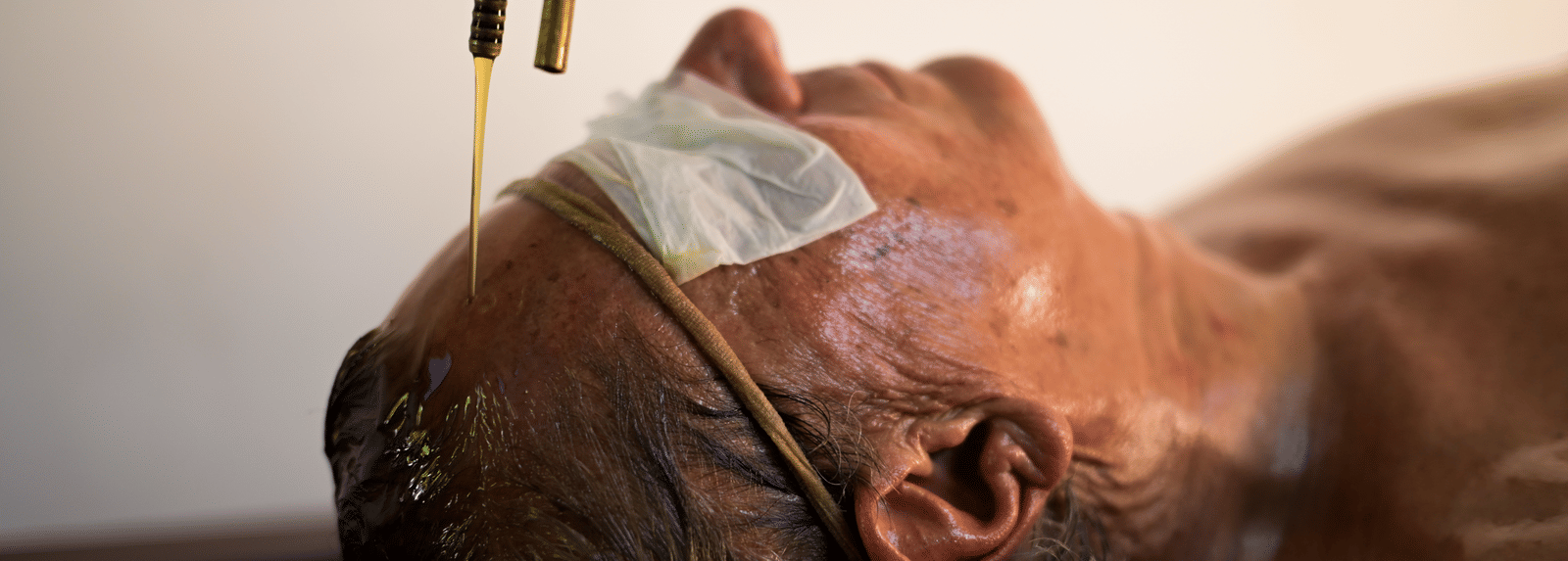 A person receiving a traditional Ayurvedic oil treatment at the Ayur On The Beach Nattika wellness centre.