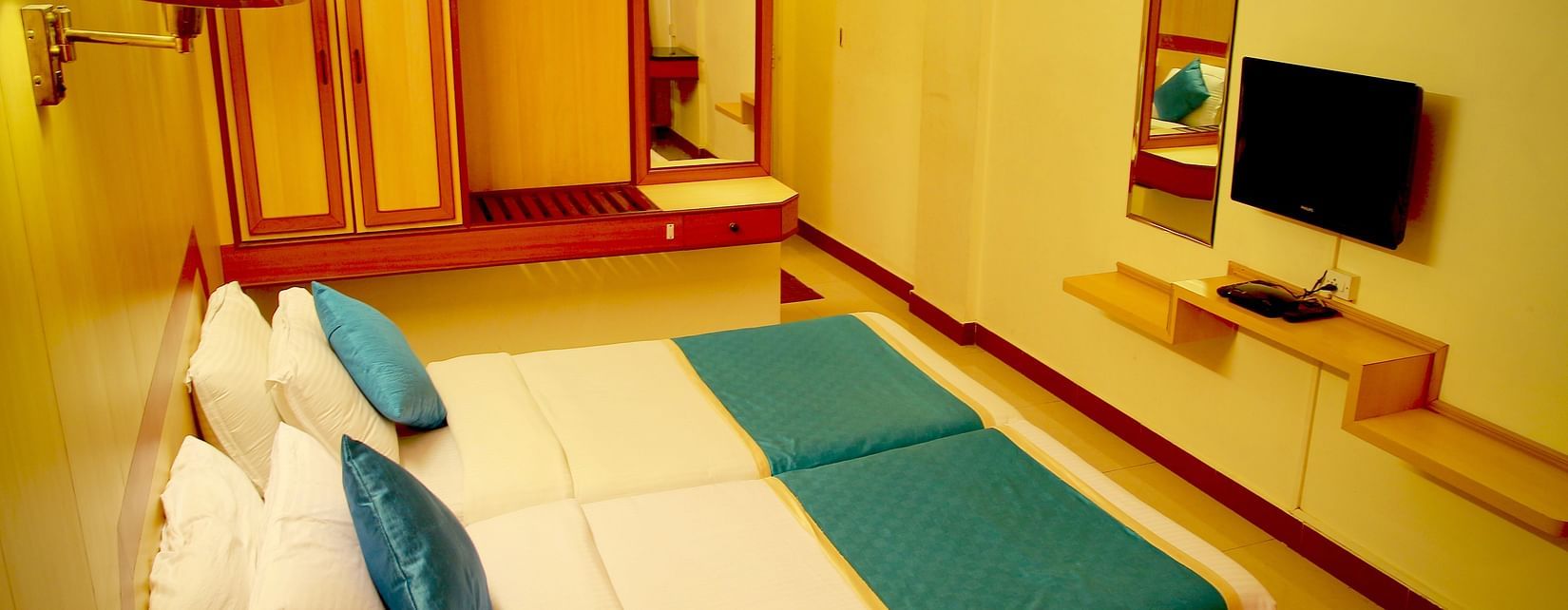 bird's eye view of a bedroom decked with double bed, television and wardrobe