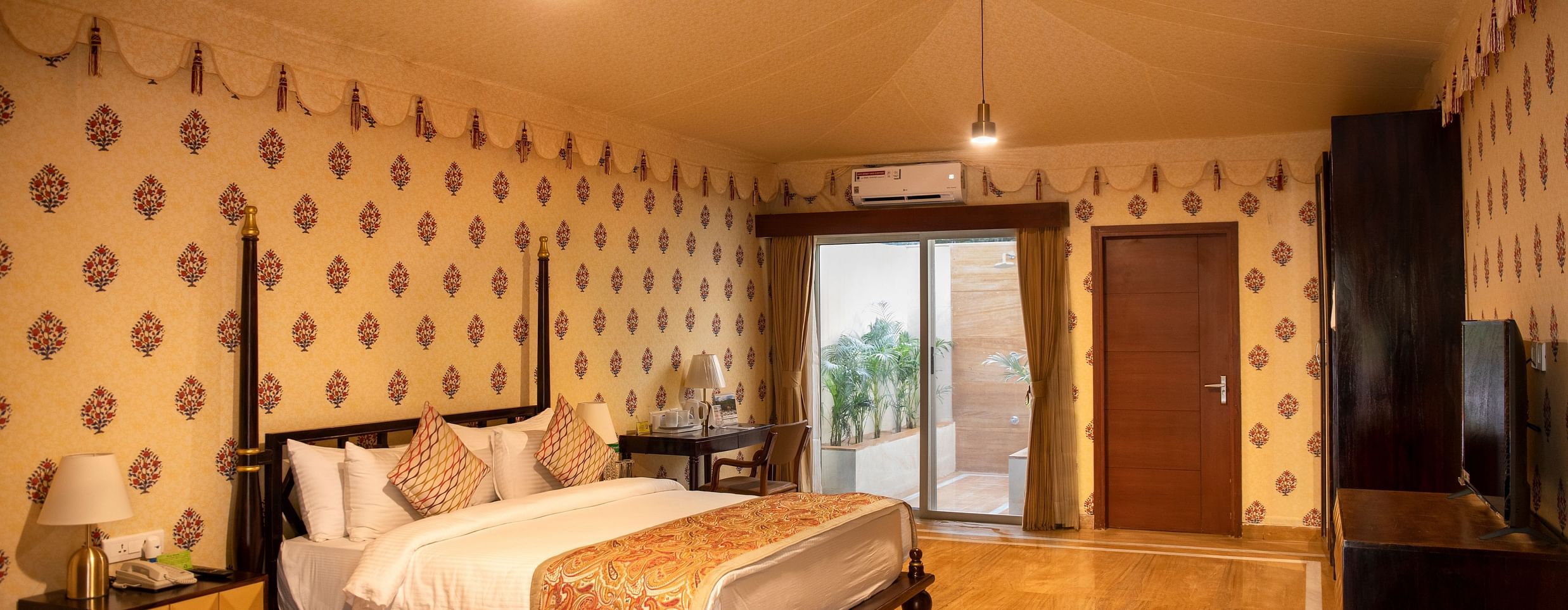 The interiors of our tent suites in Pushkar with a bed, a sofa set and tasteful decor 
