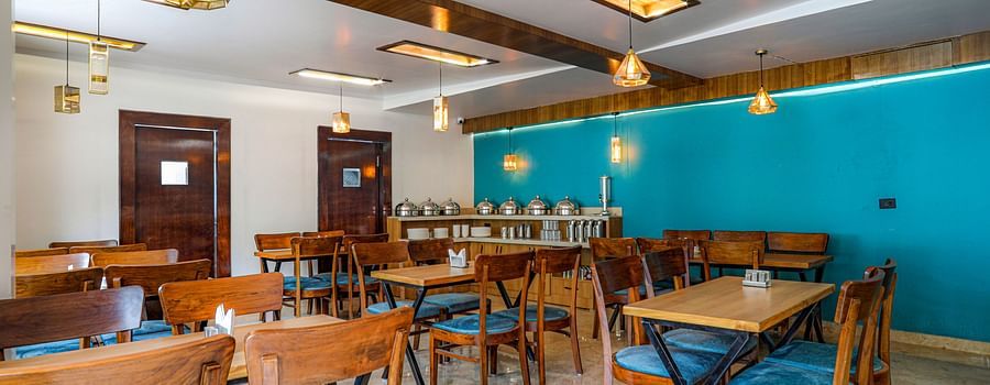 Family restaurant at Vinsober Monal, Nainital, with tables, chairs and buffet area 