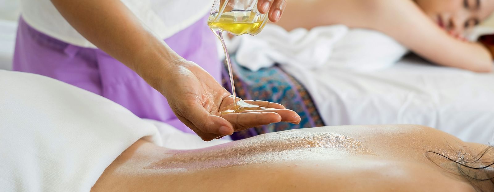 A person receiving a traditional oil massage from a masseuse - Alibu Resort Nha Trang
