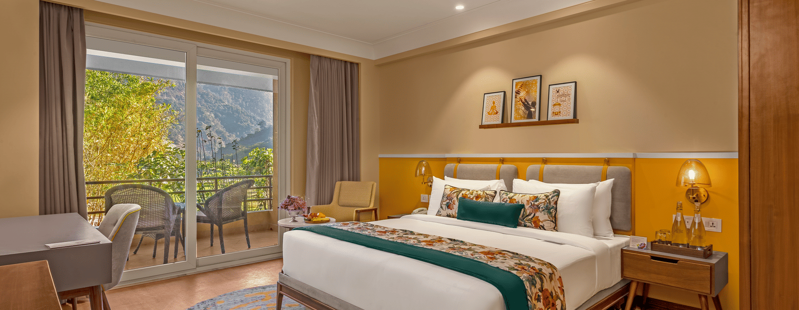 Image of a  room features a large king-size bed with a plush headboard and comfortable bedding. A comfortable armchair sits by a large window offering breathtaking views. The room also includes a wooden desk with a chair, a television, and a ceiling fan. T