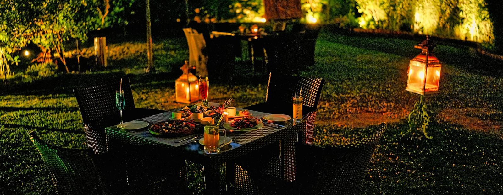 A picture of outdoor dining area with lanterns and string lights in the evening.