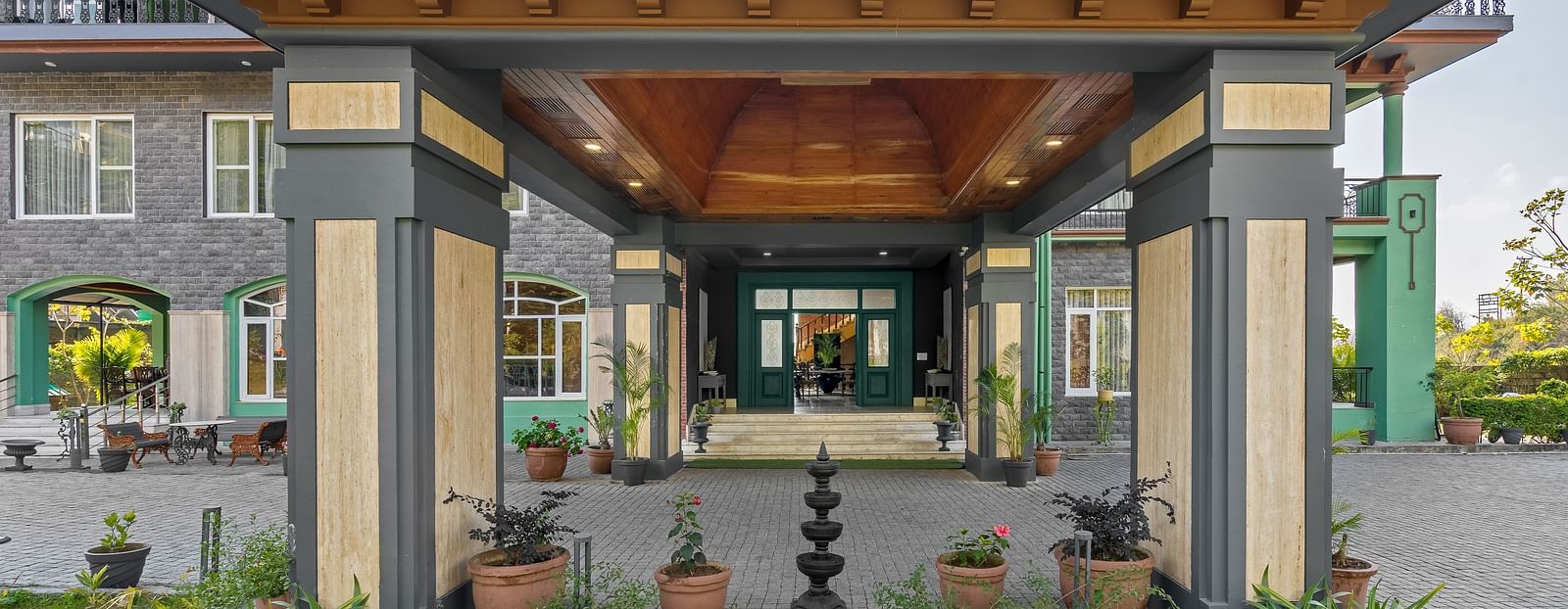 front view of the porch with decorated pillars and flower pots on the porch - Atman, Dharamshala
