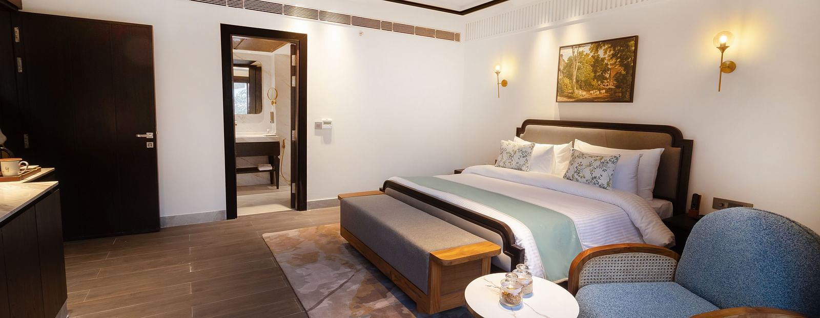 Image of Junior Suite with a bed and a chair beside the bed at Auradoon, Dehradun.