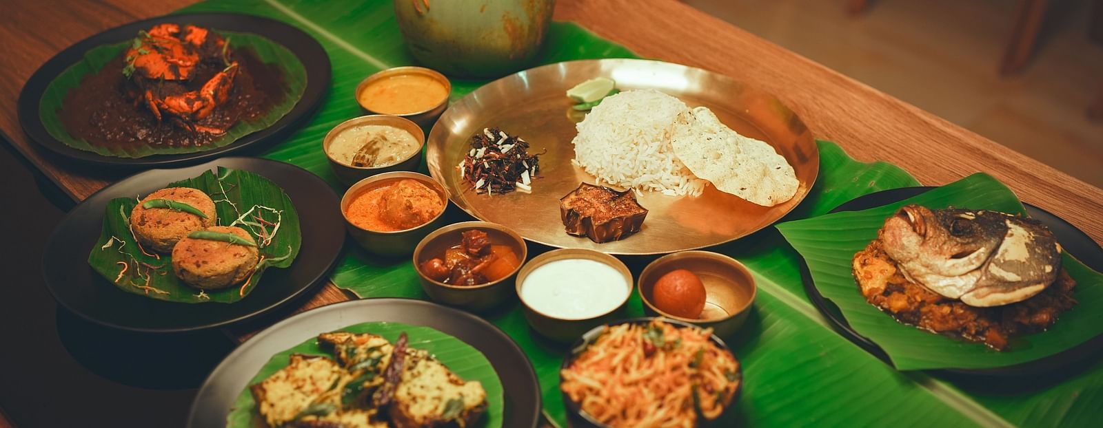 image featuring a beangli meal platter along with several bengali delicacies served on banana leaves - Dip Holidays, Birbhum