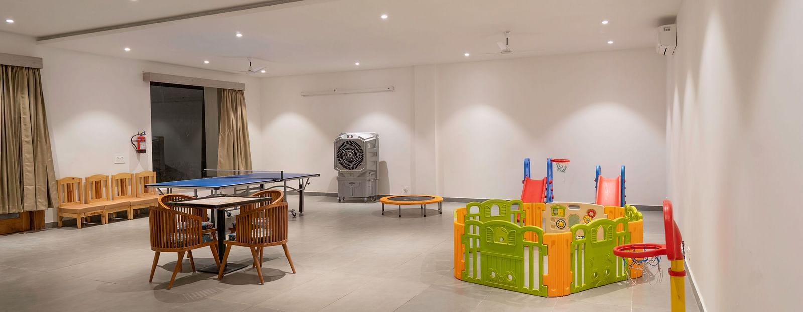 A spacious indoor play area with a pool table, a playpen, and various toys.