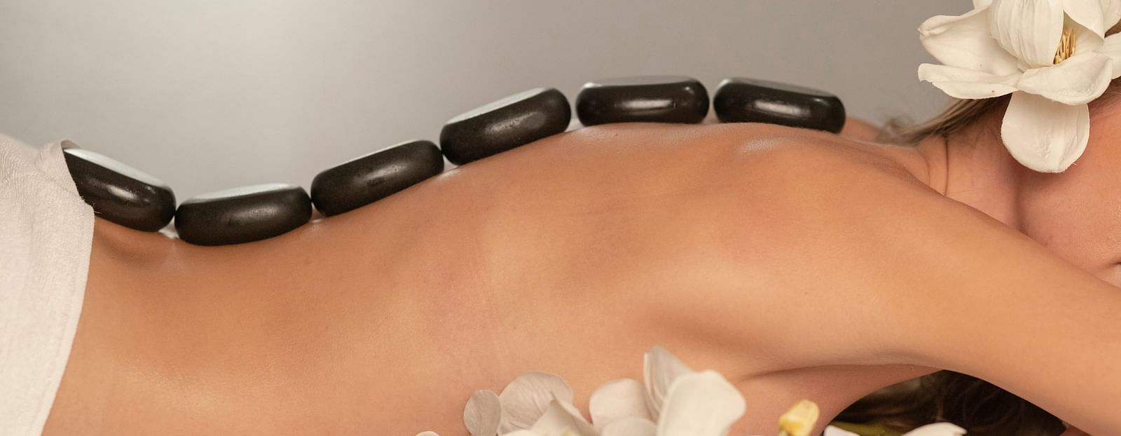 A person receiving a hot stone massage, with heated stones placed along their spine.