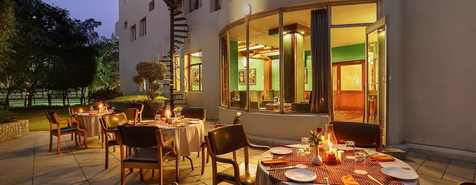 Restaurant seating outside the hotel with a beautiful sunset sky.