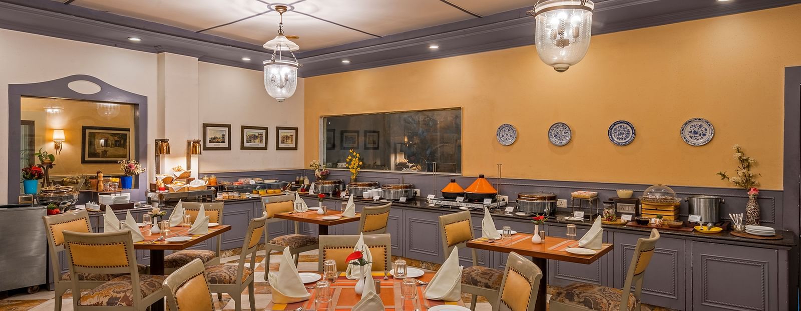 a restaurant with a buffet setting and clusters of tables and chairs - The Manor, Kashipur