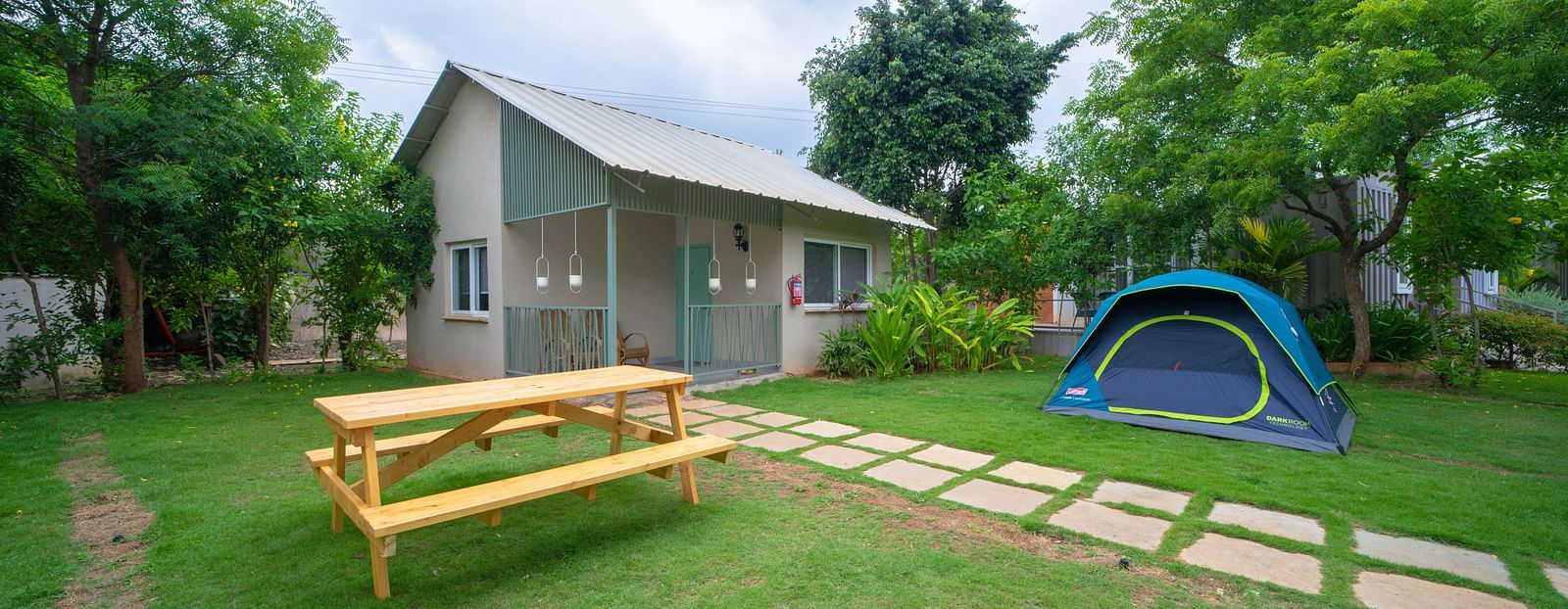 A facade image of a room with an outdoor seating arrangement and a tent - Trance Veechika Resort, Vikarabad