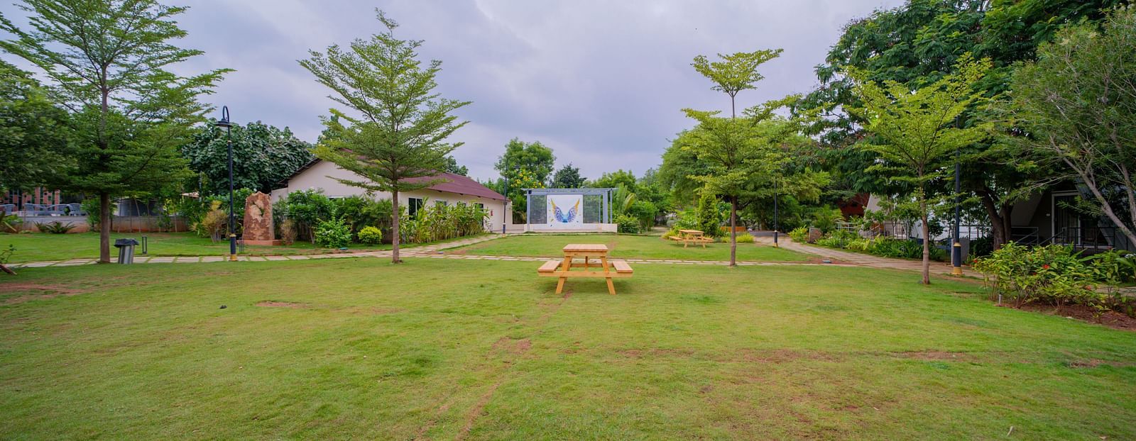 A facade image of a lawn with trees in the background - Trance Veechika Resort, Vikarabad
