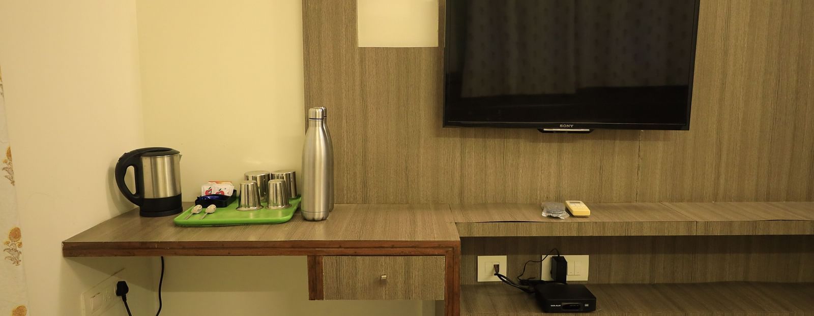 A image of the room with a TV, kettle, and desk.