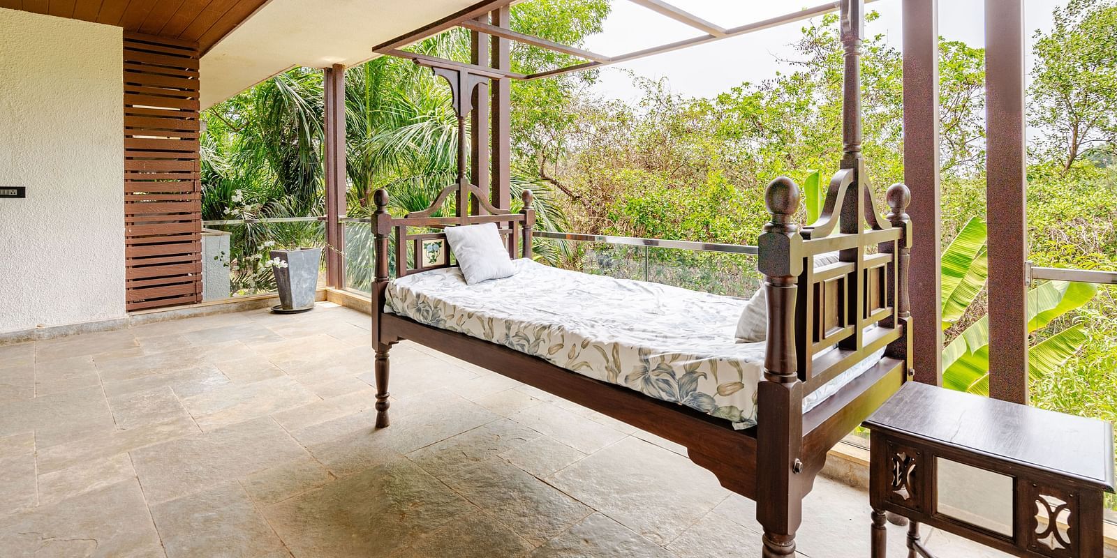 Spacious balcony with a traditional wooden daybed, ceiling fan, and forest views, offering a serene outdoor lounging space - Lindsay Manor.