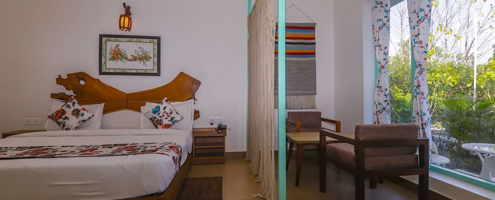 Bright and airy guest room at Vedikant Resorts The Mallard Corbett with a double bed, glass doors, and a sitting area.