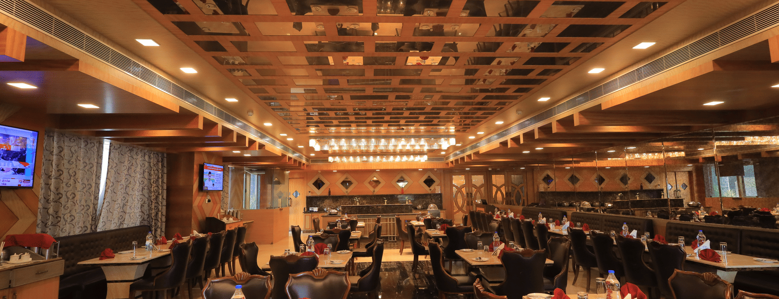 Full view of the Porchae multi-cuisine restaurant with warm lighting and well-arranged dining tables at Benzz Park, Vellore.