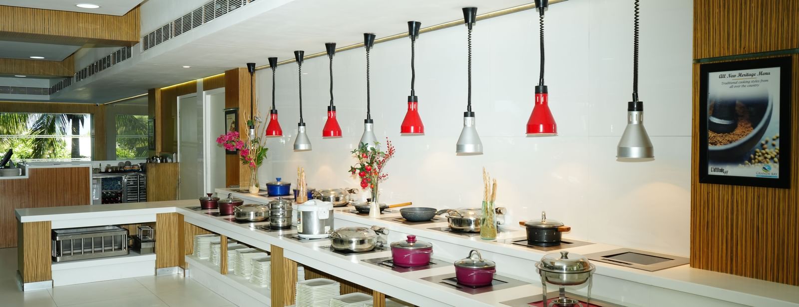 Buffet counter with multiple food stations and hanging lights above at Grande Bay Resort & Spa.