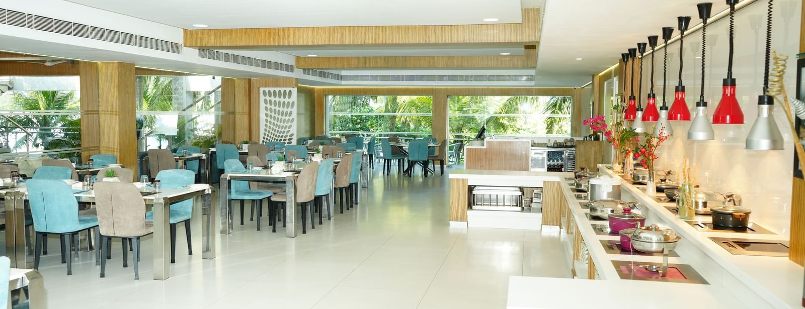 A restaurant interior with tables, chairs and a buffet counter at Grande Bay Resort & Spa.