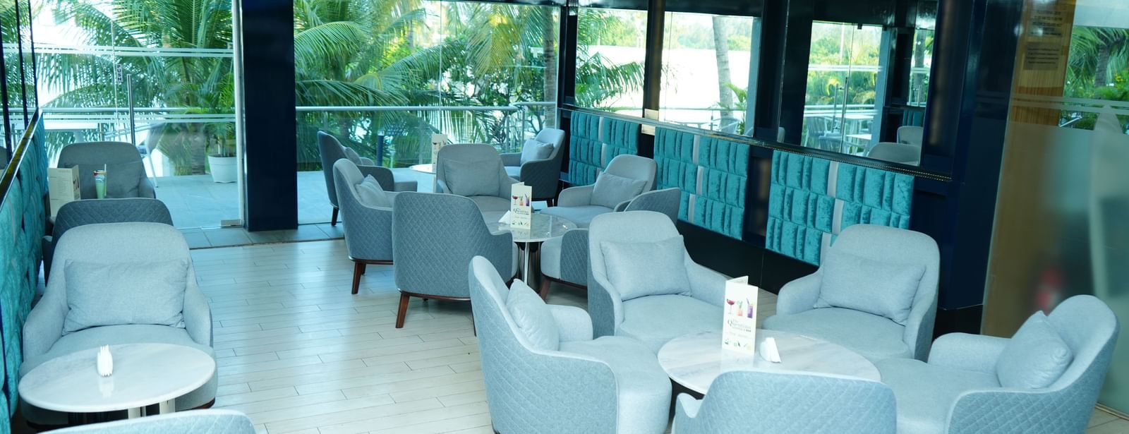 Lounge seating with armchairs and tables in a bright indoor space at Grande Bay Resort & Spa.
