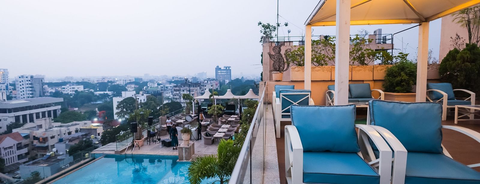 An outdoor dining space next to a pool at Hotel Ashok Nagpur.