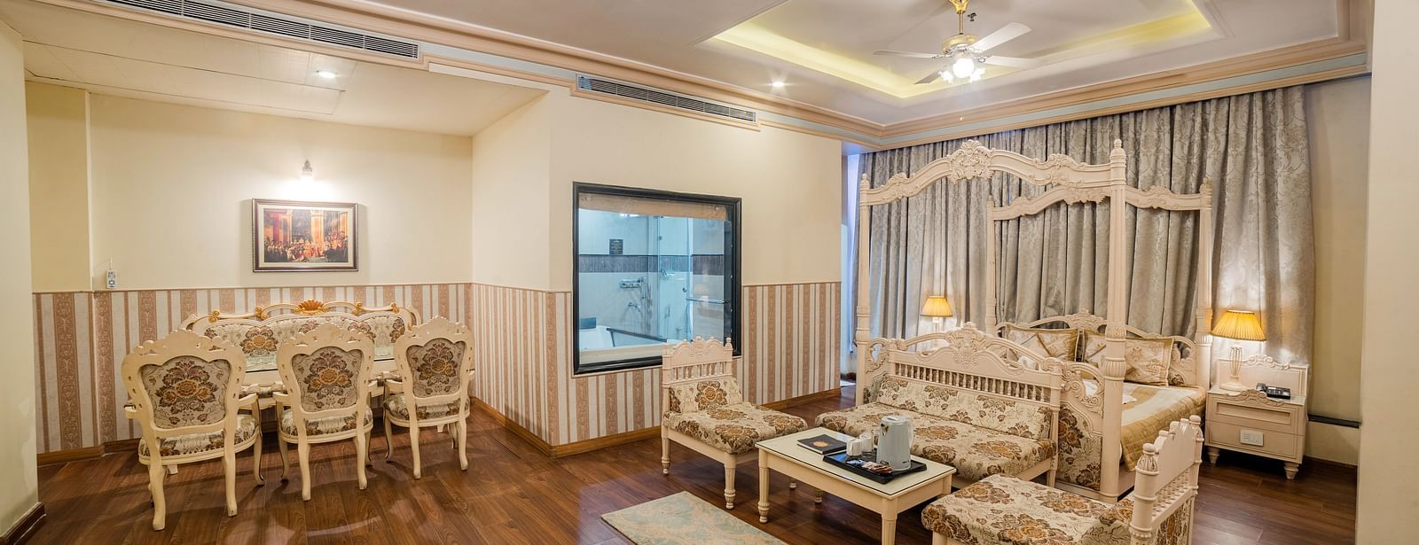 King Suite featuring ornate furniture, warm lighting, and a plush rug.- Hotel Ashok Nagpur