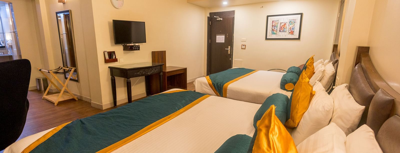 Family Room featuring two large beds facing the TV. - Hotel Ashok Nagpur