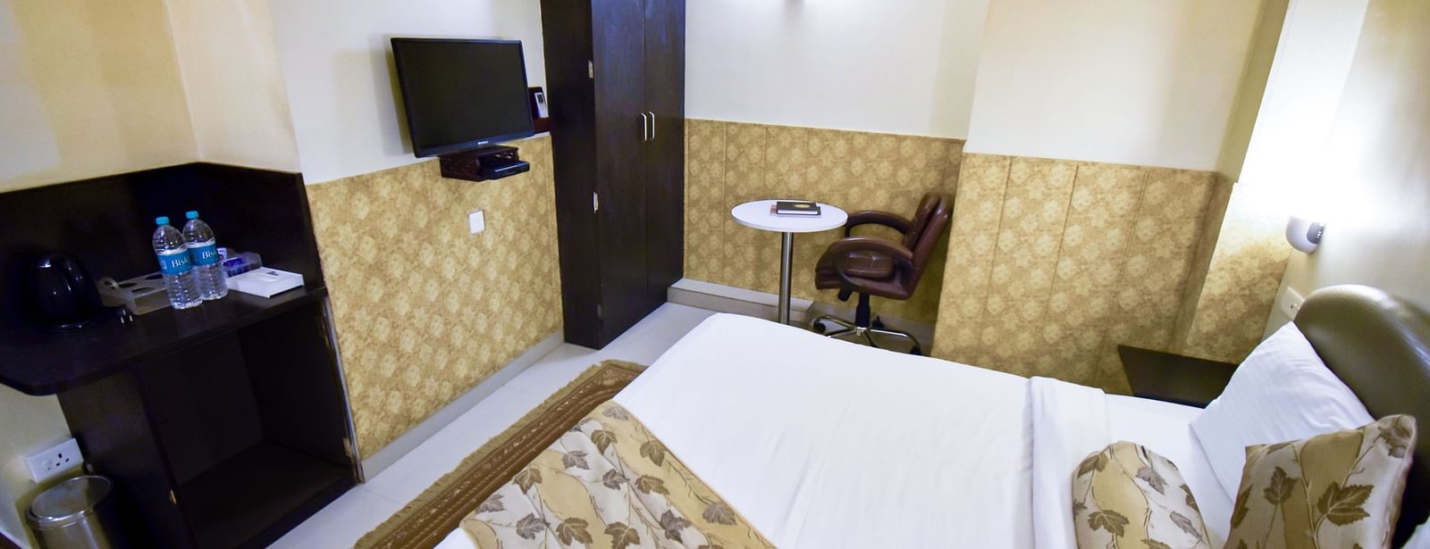 Side view from the bed of Economy Room featuring the television and a wardrobe. - Hotel Ashok Nagpur