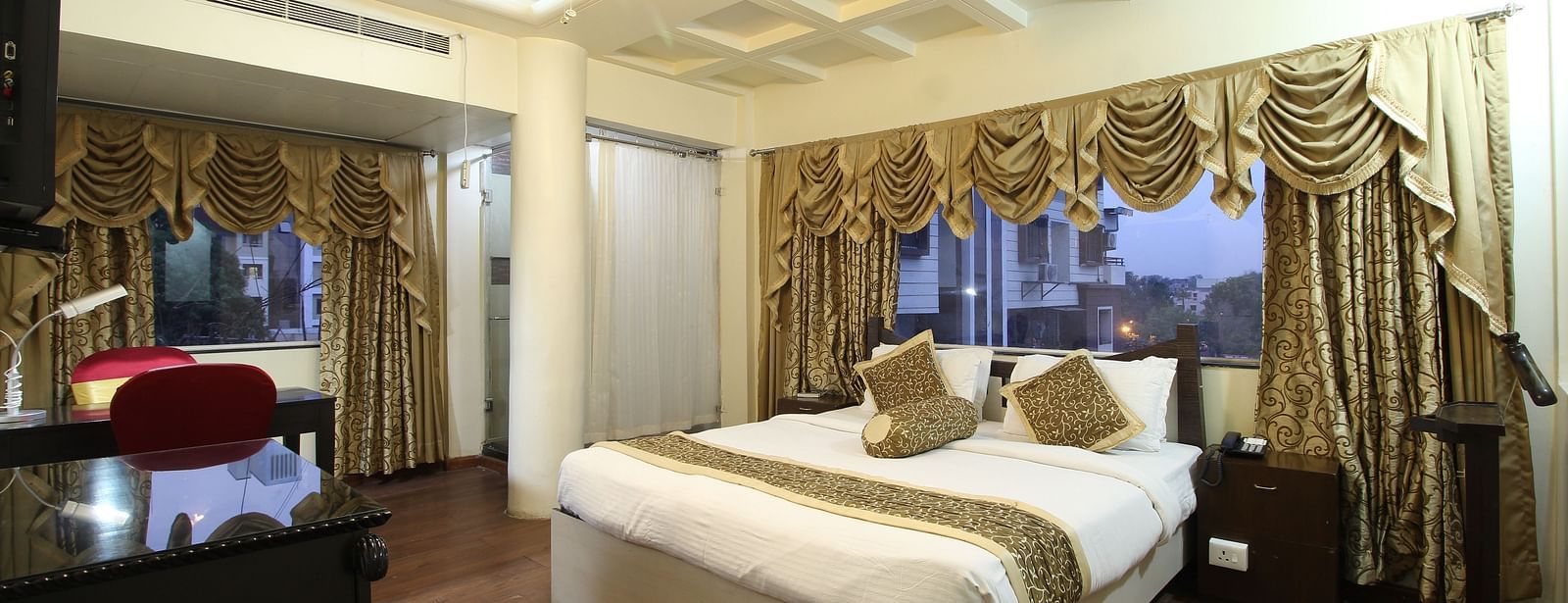 A Deluxe Room with a large bed placed in front of the TV at Hotel Ashok Nagpur.