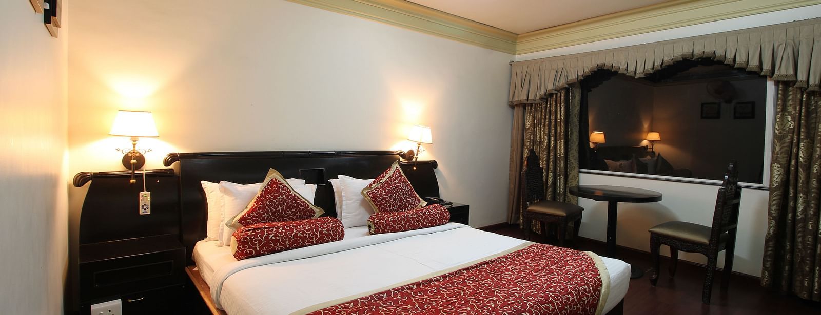 Deluxe Room featuring bed next to seating area at Hotel Ashok Nagpur.