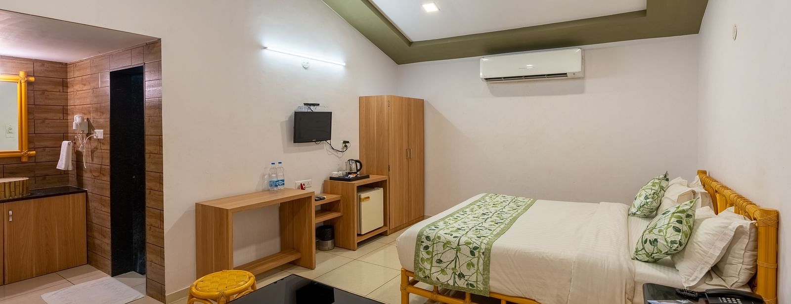 A room with a double bed, seating arrangement and work desk and chair
