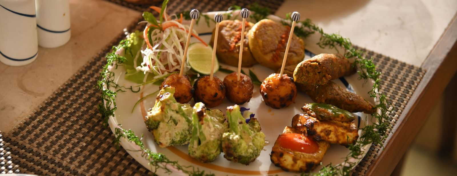 A plate of assorted food on a table at Vedic Village Spa Resort | Yagna