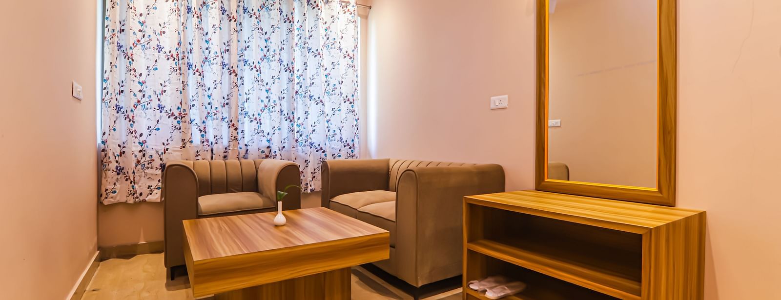 A well-furnished room at Vedikant Resorts The Mallard Corbett has a bed, seating, a mirror, and storage units.